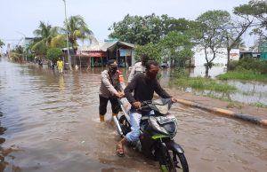 Anggota Polsek Sunda Kelapa Sigap Bantu Pengendara Sepeda Motor Terjebak Banjir